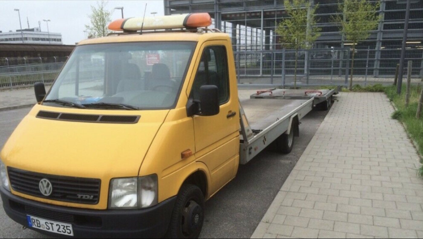Gelber Abschleppwagen der Fa. Stache mit leerer Ladefläche